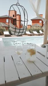 洛斯雷特斯Punta Piedra cabañas & suites的一张桌子,上面放着两杯葡萄酒和一根或一根