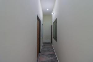 JhājraSPOT ON The Greenwoods Retreat的白色墙壁房屋的走廊