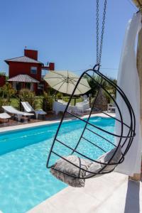 洛斯雷特斯Punta Piedra cabañas & suites的悬在游泳池上的秋千
