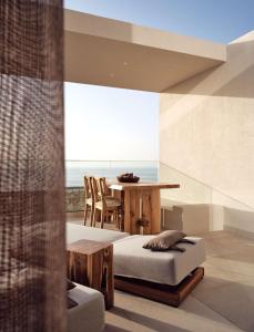 帕诺尔莫斯雷斯蒙The Royal Senses Resort & Spa Crete, Curio Collection by Hilton的客厅配有桌子和床。