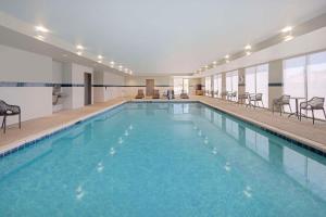 克洛维斯Home2 Suites By Hilton Clovis的大楼内带椅子的大型游泳池