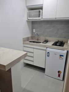 维拉维尔哈Flat Praia da Costa的白色的厨房配有水槽和冰箱