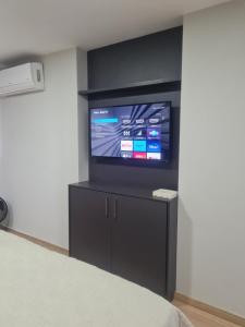 维拉维尔哈Flat Praia da Costa的卧室设有壁挂式电视