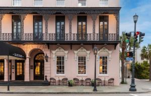 查尔斯顿Mills House Charleston, Curio Collection by Hilton的粉红色的建筑,在街上设有阳台