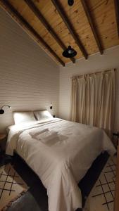 乌鲁比西Skyline Urubici - Barn的卧室内的一张白色大床,拥有木制天花板