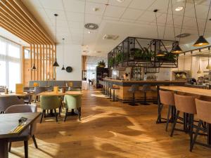 Hagenberg im MühlkreisBest Western Parkhotel Hagenberg的一间带桌椅的餐厅和一间酒吧