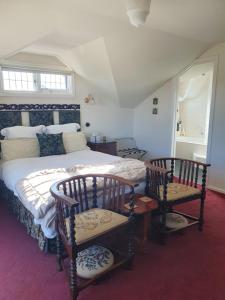 莫宁顿Mornington Guest House的一间卧室配有一张大床和两把椅子