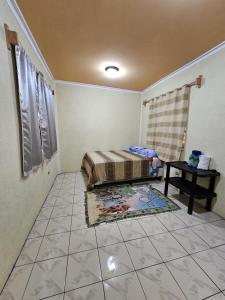 帕纳哈切尔Hostal flor del lago的卧室配有1张床和1张桌子,铺有瓷砖地板。