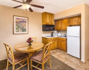 棕榈泉WorldMark Palm Springs - Plaza Resort and Spa的厨房配有桌子和白色冰箱。