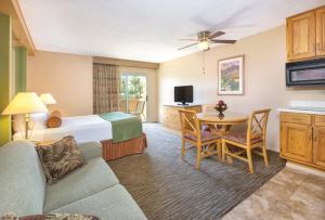 棕榈泉WorldMark Palm Springs - Plaza Resort and Spa的酒店客房配有一张床铺和一张桌子。