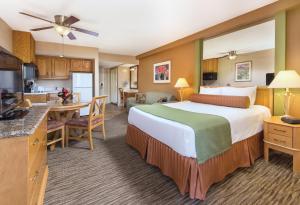 棕榈泉WorldMark Palm Springs - Plaza Resort and Spa的酒店客房设有一张大床和一个厨房。
