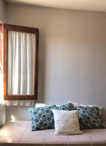 圣萨尔瓦多德朱Casa Olavarria的卧室配有带枕头的床铺和窗户。