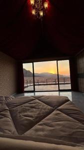 瓦迪拉姆Wadi Rum Golden Valley的卧室设有一张大床,卧室设有大窗户