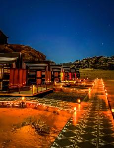 瓦迪拉姆Wadi Rum Golden Valley的沙漠中夜晚有灯光的建筑