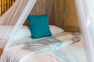西塔努Bamboo Bay Island Resort的一张带蚊帐和蓝色枕头的床