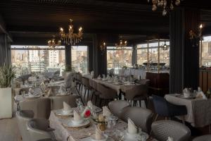 奥兰Melissa Hotel的餐厅设有白色的桌椅和窗户。