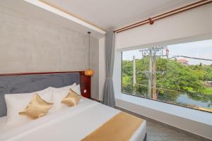 Phumĭ KântrákSerenity Suites d'Angkor的一间卧室设有一张床和一个大窗户