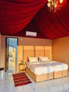 瓦迪拉姆Wadi Rum Golden Valley的一间卧室设有一张红色天花板的大床