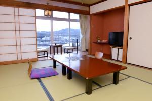 平戸市旗松亭日式旅馆的客厅设有桌子和大窗户