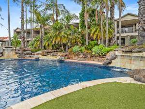 穆尔瓦拉Yarrawonga Lakeside Apartment 25的一座别墅前方的棕榈树游泳池