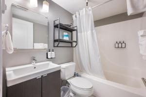 西雅图Oxford Apartment by At Mine Hospitality的白色的浴室设有水槽、卫生间和浴缸。