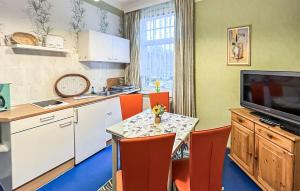 Stubbenfelde1 Bedroom Stunning Apartment In Klpinsee-usedom的厨房配有桌椅和电视。