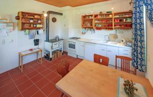 马林Stunning Home In Penzlin Ot Krukow With Kitchen的厨房配有白色橱柜和木桌