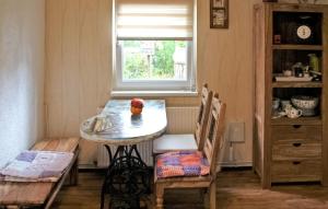 卢布明Pet Friendly Home In Lubmin seebad With Kitchen的窗户客房内的小桌子和椅子