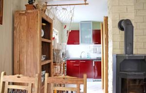 卢布明Pet Friendly Home In Lubmin seebad With Kitchen的一间带红色橱柜和炉灶的厨房