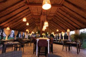 马拉喀什THE FARM LODGES & Private pool的餐厅设有桌椅和吊灯。