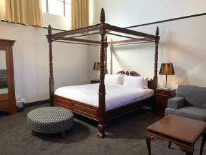 霍巴特The Macquarie Hobart的一间卧室配有四柱床和沙发
