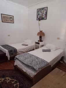 CareneroParaíso frente al Mar.的一间卧室配有两张床和一张带台灯的桌子