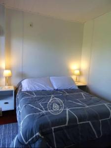 塞拉纳镇Casa Florida的一间卧室配有一张带蓝色被子的床和两盏灯。