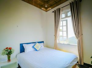 大叻Villa Hang Nga 2的卧室配有白色的床和窗户