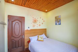 大叻Villa Hang Nga 2的一间卧室配有一张床和一扇木门