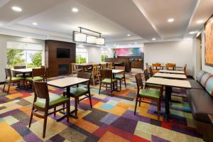 康科德康科德费尔菲尔德客栈的一间设有桌椅的餐厅,铺着色彩缤纷的地毯