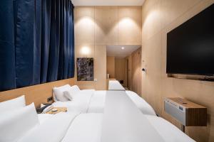 首尔The Hyoo Sik ANNK Hong Dae Branch的酒店客房设有两张床和一台平面电视。