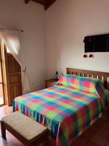 科潘玛雅遗址La Casa de Dona Irma Townhouse的一间卧室配有一张带彩色毯子的床