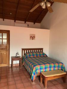 科潘玛雅遗址La Casa de Dona Irma Townhouse的一间卧室配有一张床、一张桌子和一个窗户。