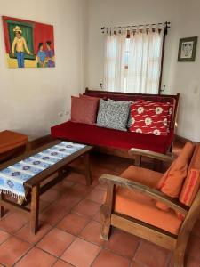 科潘玛雅遗址La Casa de Dona Irma Townhouse的客厅配有红色的沙发和桌子