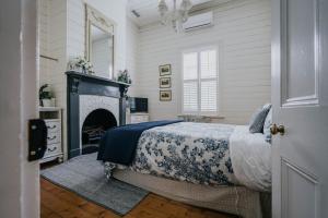 戴尔斯福特Lake Daylesford Country House的一间卧室配有一张床和一个壁炉