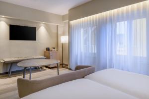马德里马德里卡尔顿万豪AC酒店的酒店客房配有一张床铺和一张桌子。