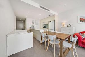 金斯顿Canberra Lakefront 2-Bed with Pool, Gym & Parking的厨房以及带桌椅的用餐室。