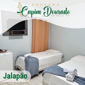 托坎廷斯州圣费利克斯Pousada Capim Dourado Jalapão São Felix TO的一间设有两张床和一台电视的房间
