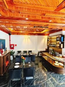 胡志良Olagi Hotel 2的餐厅设有木制天花板和桌椅