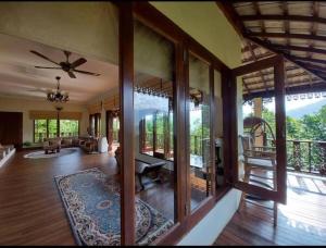 Kampong Sungai TamuHulu Tamu Off Grid Morrocan styled Hill Top Villa的大型客厅设有吊扇和玻璃门。