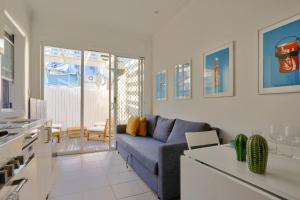 悉尼2 Bedroom House Situated at the Centre of Surry Hills 2 E-Bikes Included的一间带蓝色沙发的客厅和一间厨房
