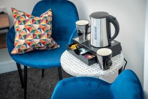 怀特黑Kings Arms Suites - Deluxe Room - En-Suite - Self Check In的蓝色椅子和一张桌子,上面有咖啡壶
