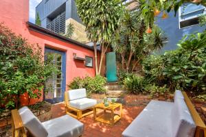 悉尼Close to City 3 Bedroom House Surry Hills 2 E-Bikes Included的天井配有沙发、椅子和桌子