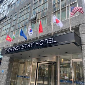 首尔First Stay Hotel的大楼前方有旗帜的酒店